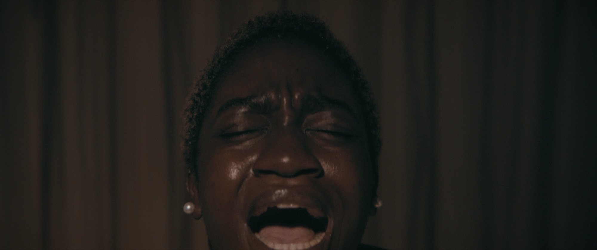 Close portrait of a woman crying in a dimly lit room